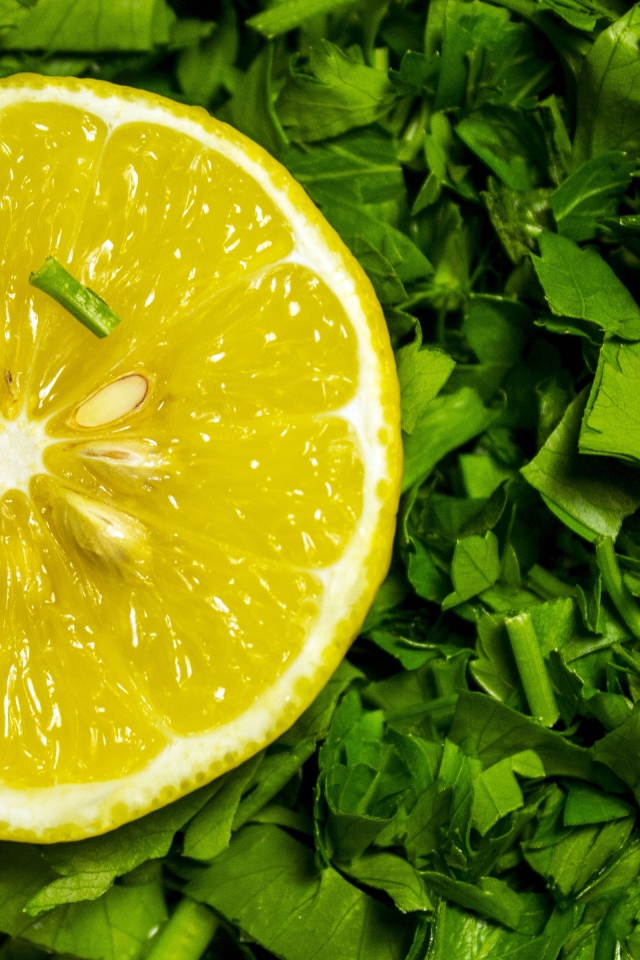Половина желтого лимона с нарезанной зеленью петрушки 