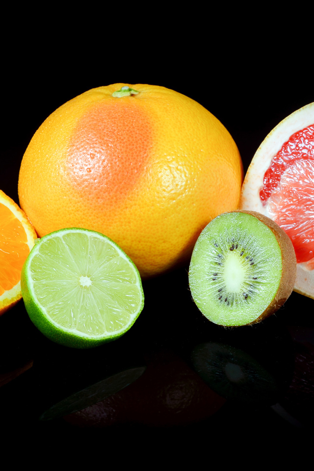 Апельсины, грейпфруты,  лайм и киви на черном фоне