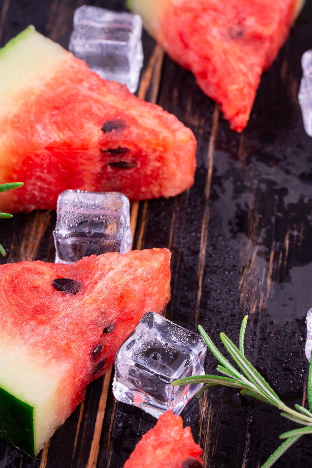 Кусочки арбуза на столе со льдом и розмарином