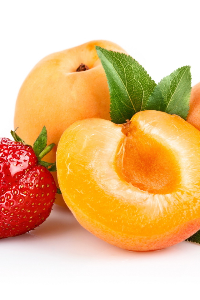 Спелые абрикосы с ягодами клубники на белом фоне