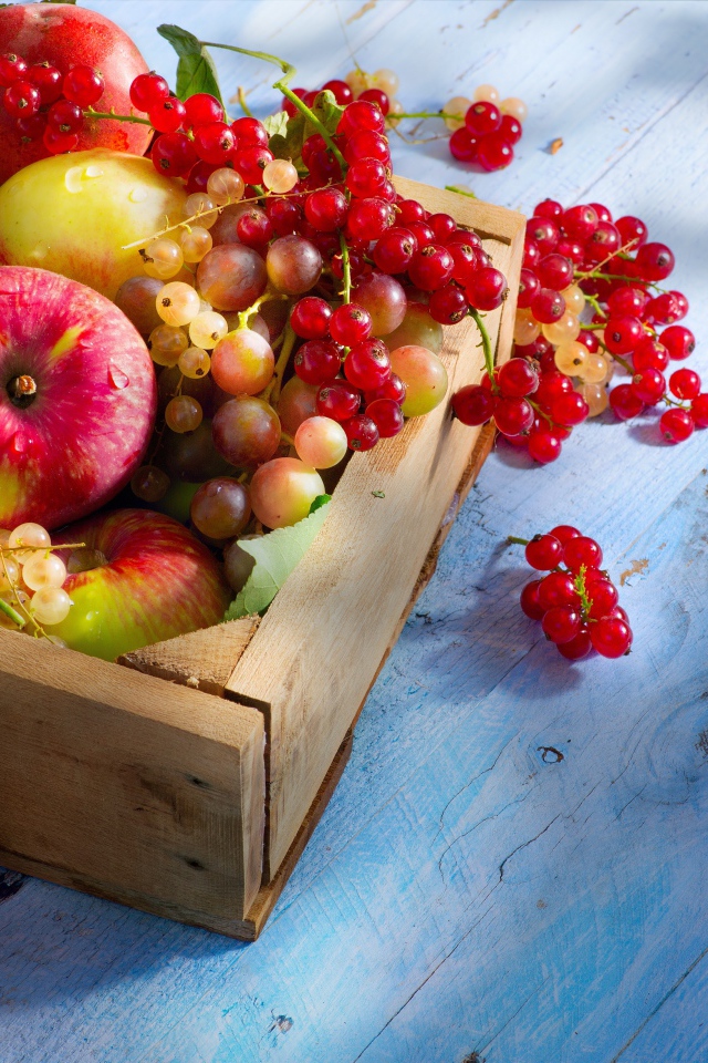 Спелые сочные ягоды и фрукты на столе в деревянном ящике