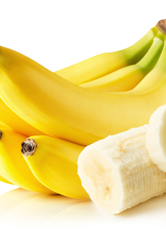 Спелые желтые бананы на белом фоне