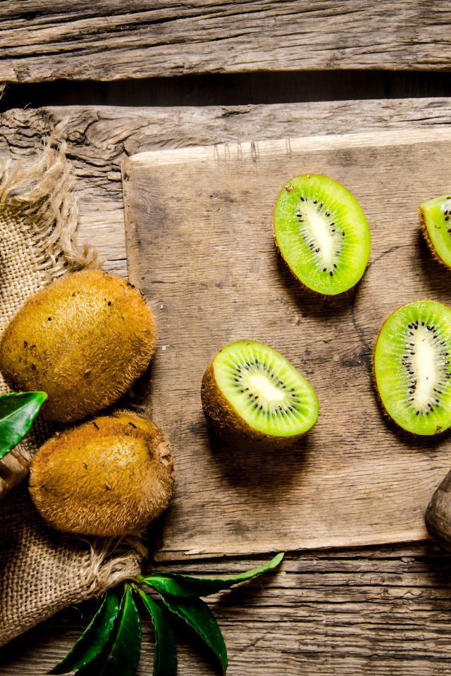 Нарезанное киви на разделочной доске с ножом