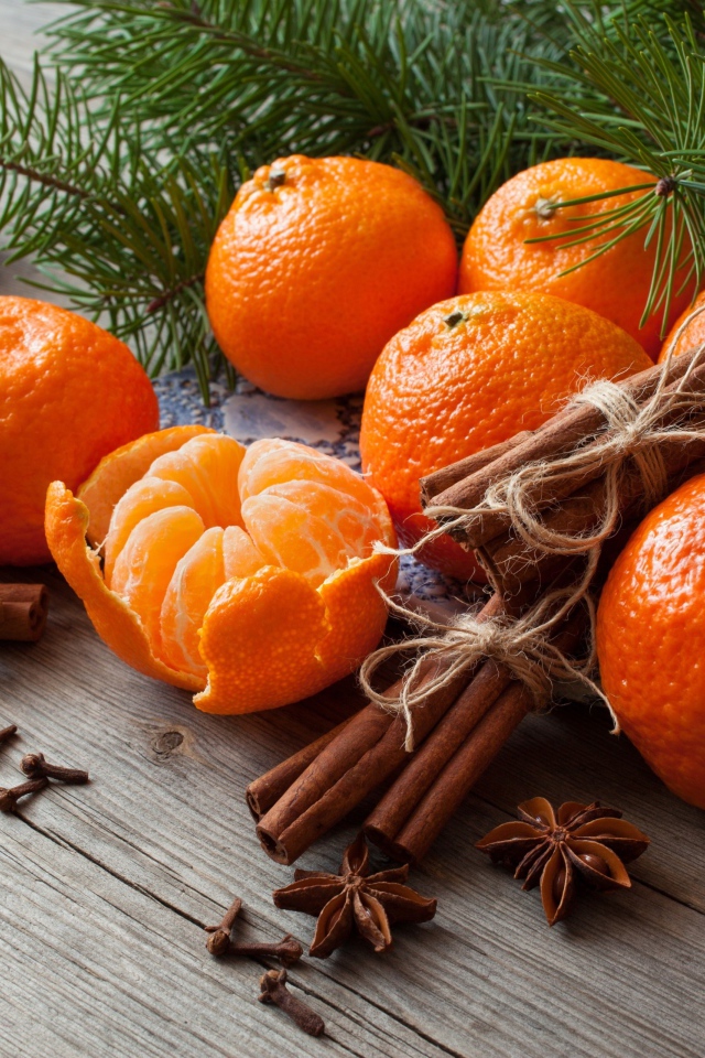 Вкусные спелые мандарины с корицей и бадьяном на столе с еловой веткой