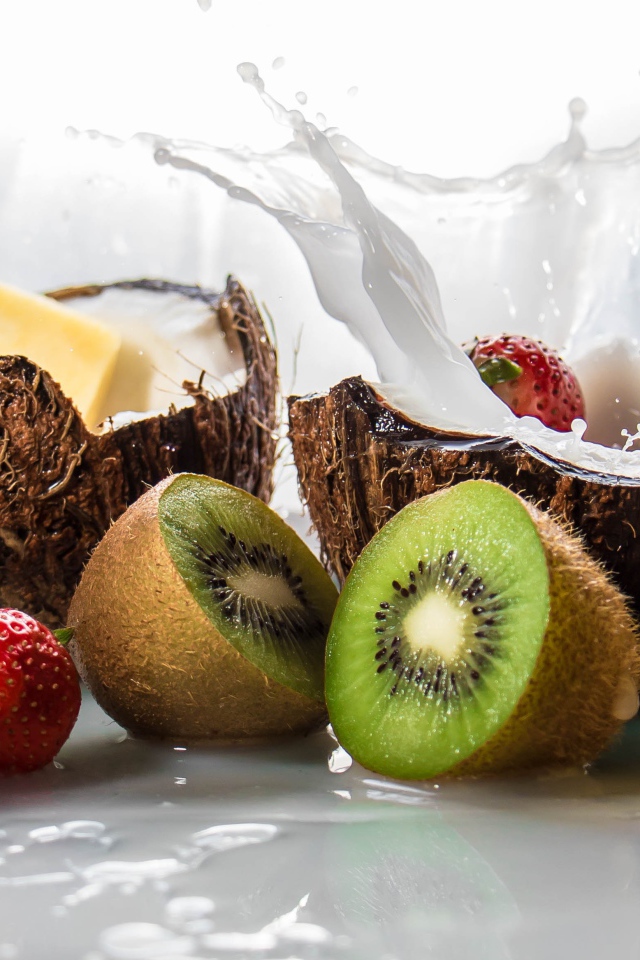 Тропические фрукты кокосы, ананасы и киви на белом фоне с клубникой