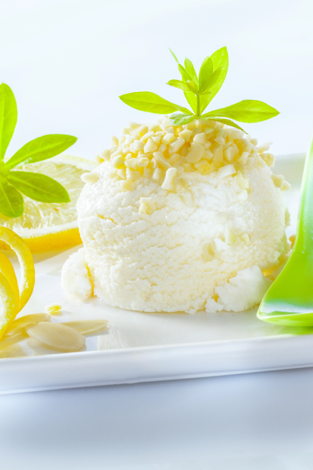 Шарик лимонного мороженого с фисташками с зеленой ложкой