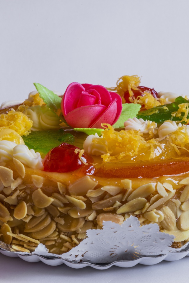 Красивый торт с кремом и ягодами украшен розовым цветком