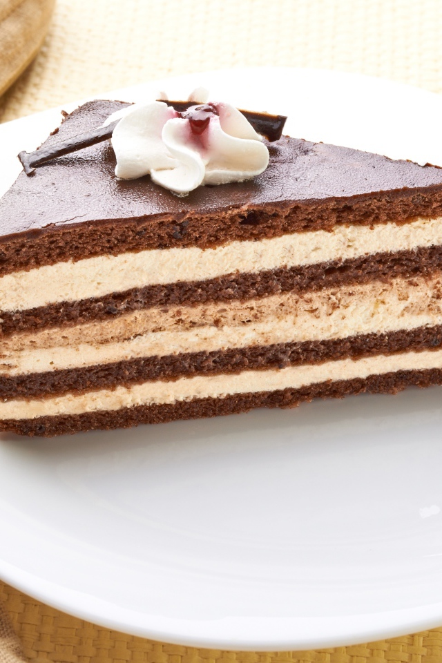 Большой кусок торта с кремом украшен цветком