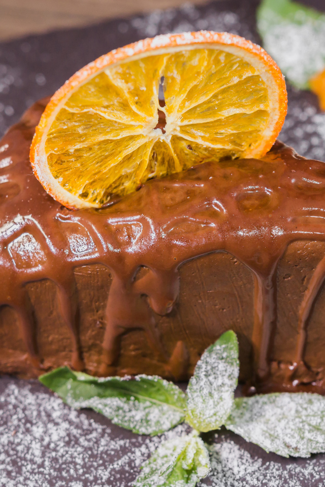 Кусок пирожного с шоколадом и кусочком апельсина