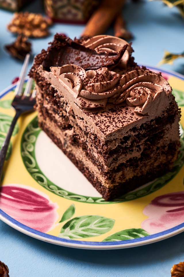 Кусок торта с кремом и шоколадом на тарелке 