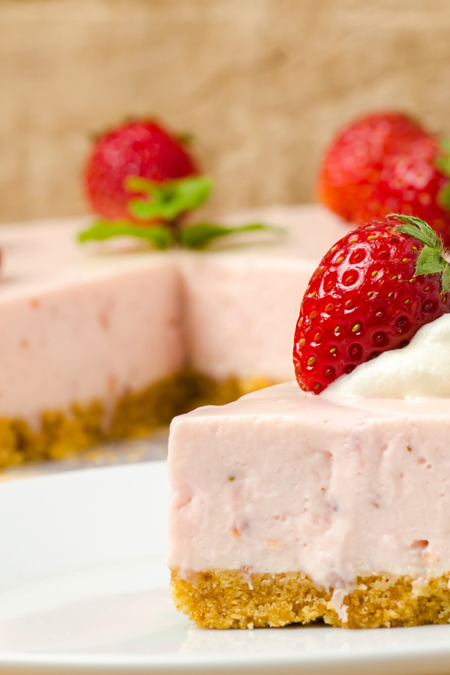 Кусок торта с клубникой на белой тарелке