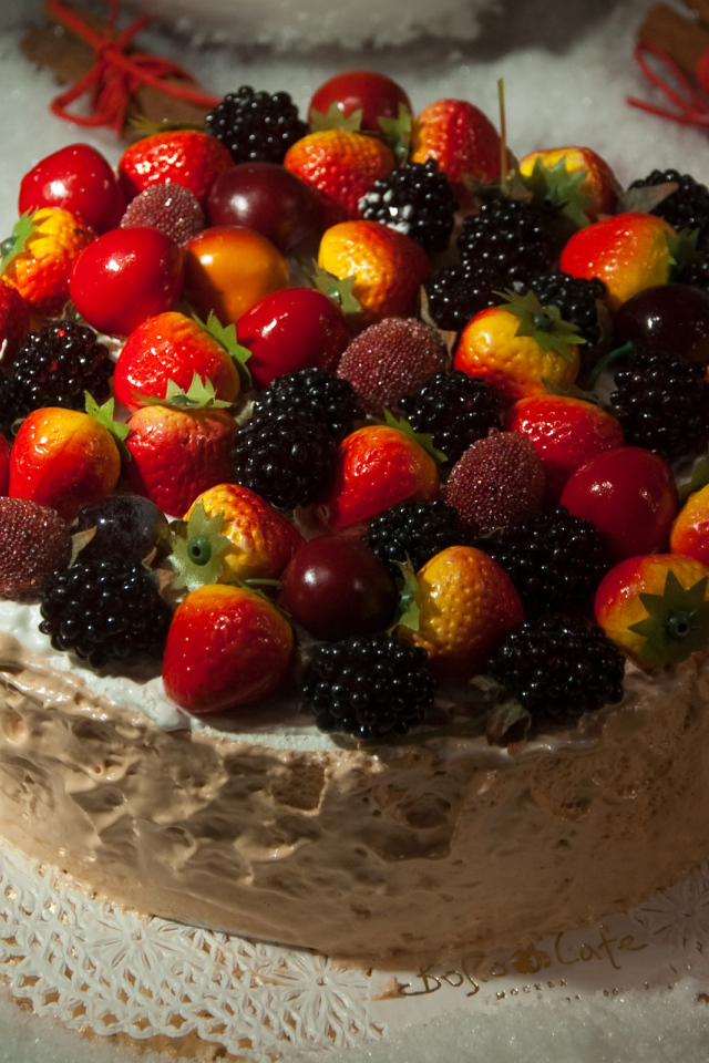 Аппетитный торт с ягодами на столе 