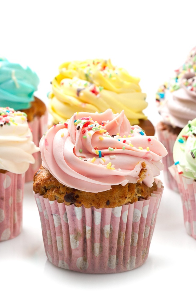 Аппетитные капкейки с кремом на белом фоне