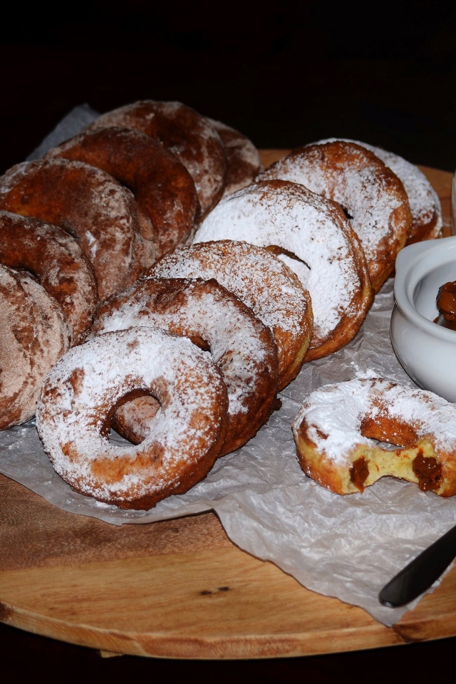 Аппетитные пончики со сгущенкой и свежим молоком на столе