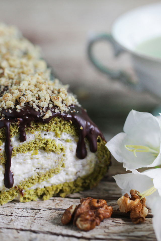 Аппетитный сладкий рулет с шоколадом на столе с белыми цветами колокольчика