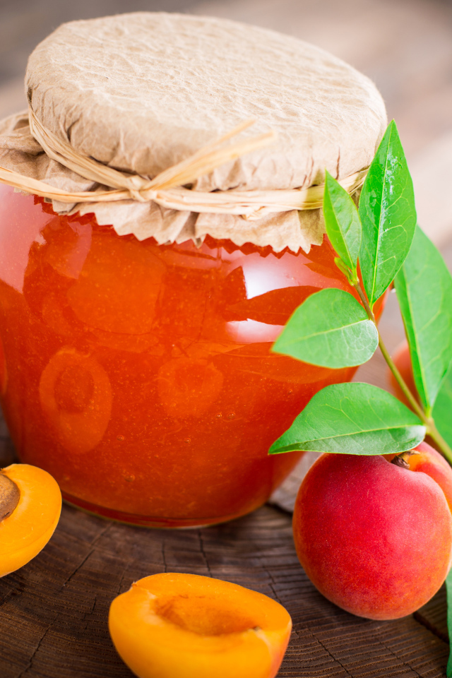 Абрикосовое варенье в банке на столе с абрикосами