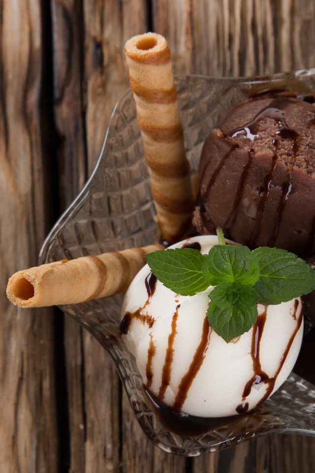 Шарик сливочного и шоколадного мороженого в пиале с трубочками