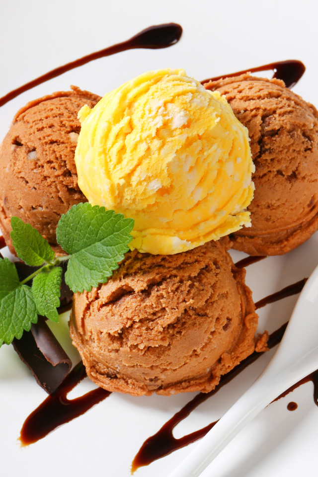 Шарики кофейного и фруктового мороженого на белой тарелке