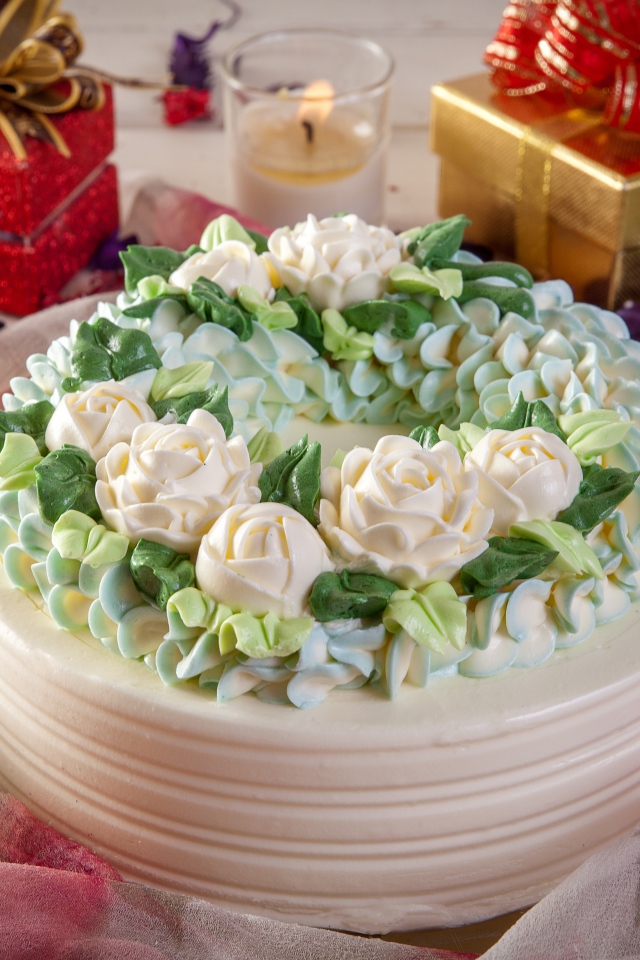 Красивый праздничный торт на столе с подарками и свечами