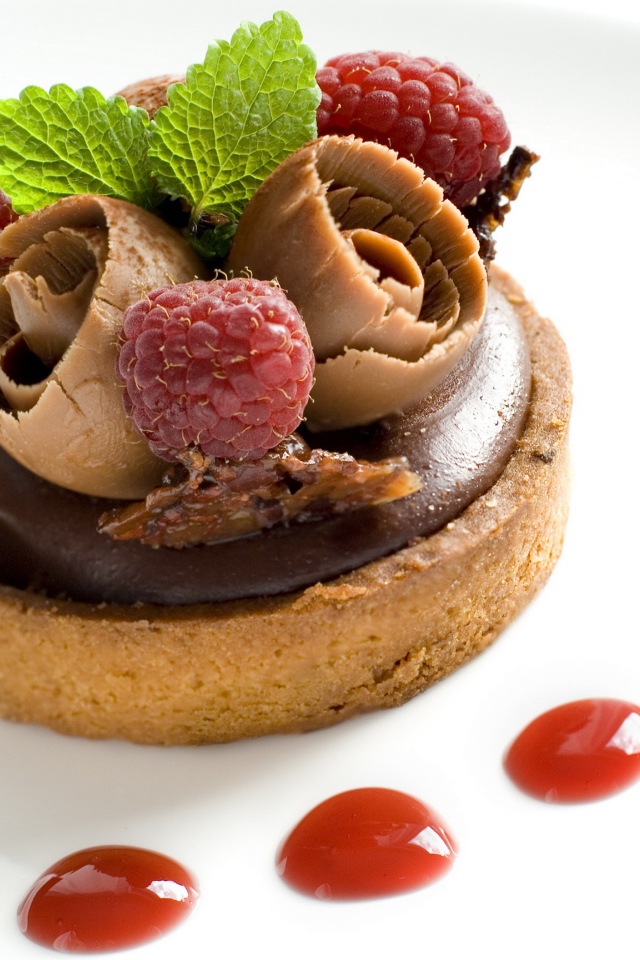 Пирожное с шоколадом и ягодами малины на белом фоне