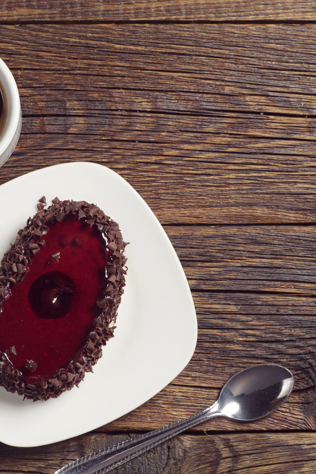 Пирожное с шоколадом на деревянном столе с чашкой кофе