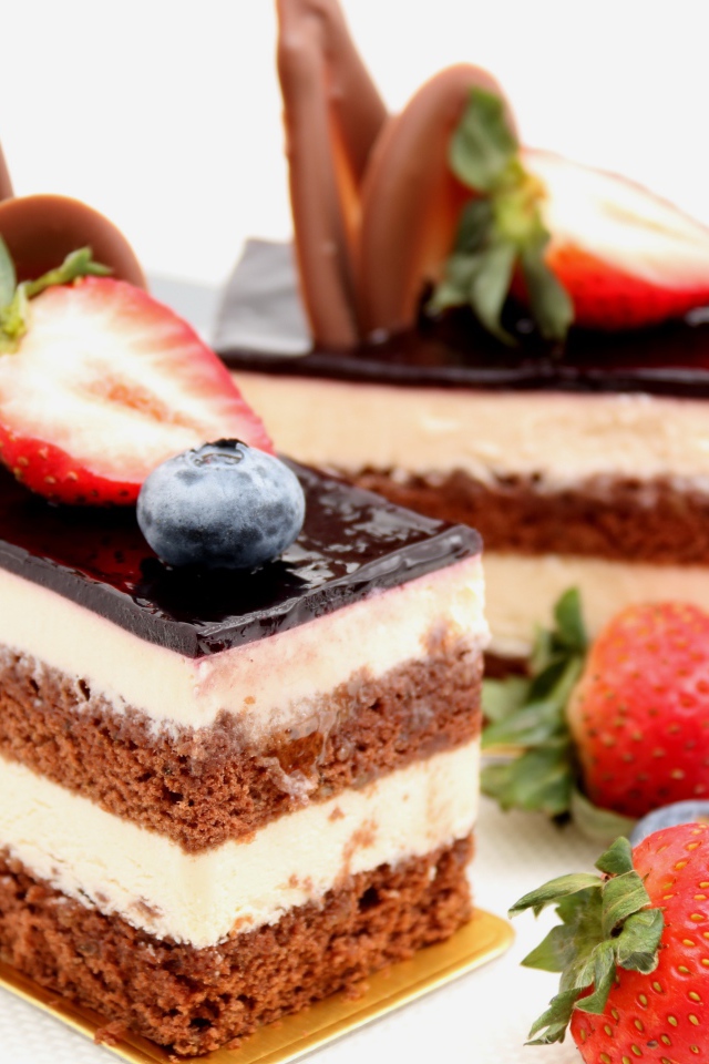 Пирожные с шоколадом, кремом и ягодами клубники и черники