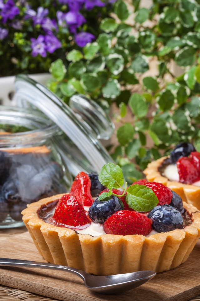 Пирожные с ягодами клубники и черники на столе