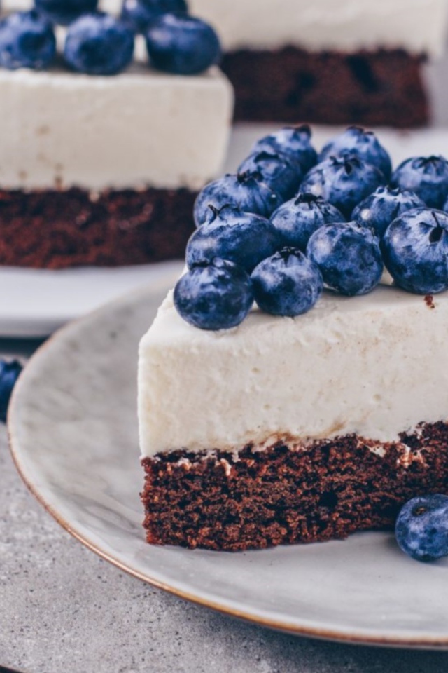 Чизкейк с ягодами черники на тарелке