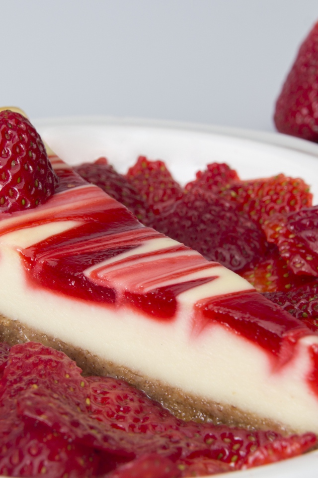 Чизкейк с ягодами клубники в белой тарелке 