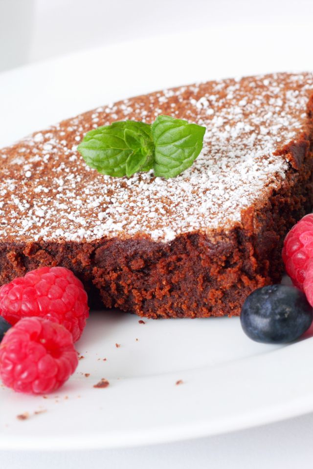 Шоколадный десерт брауни с ягодами малины и черники