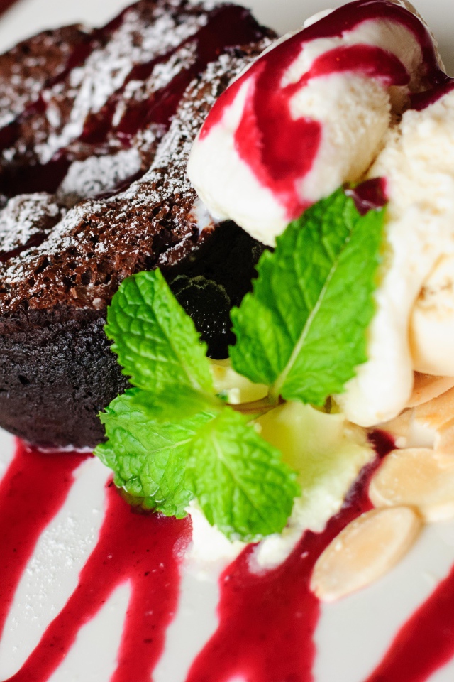 Шоколадное пирожное с мороженым и джемом на тарелке