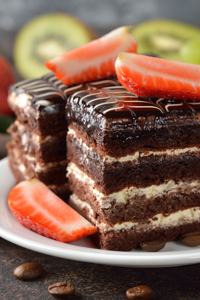 Шоколадное пирожное с клубникой и виноградом на столе