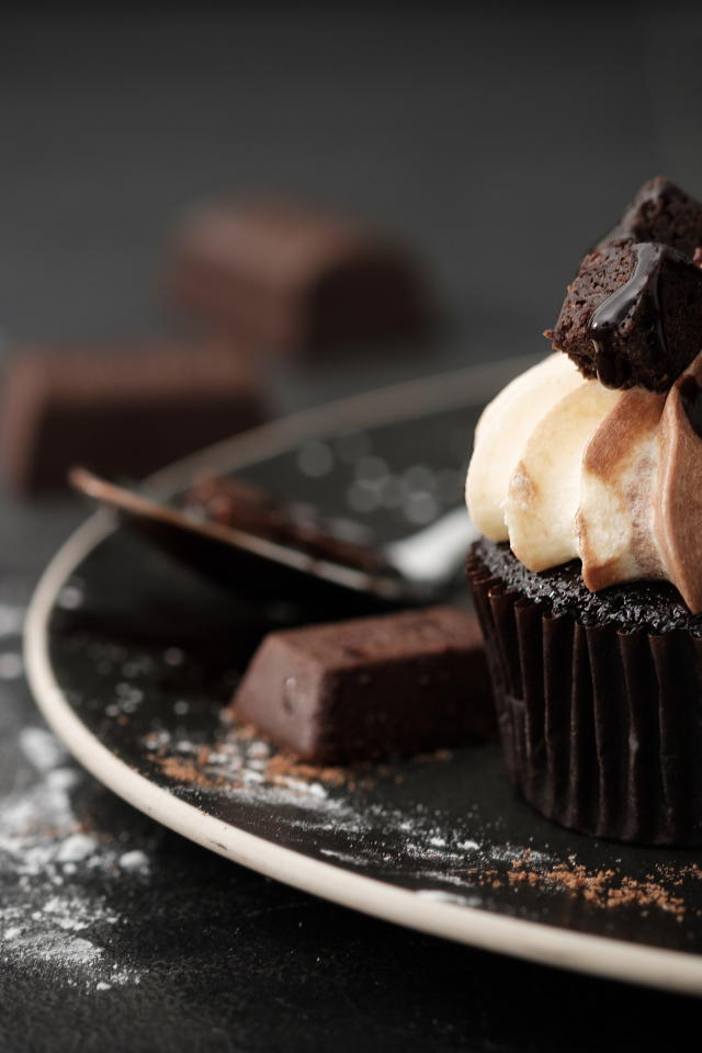 Шоколадный маффин с кремом на тарелке 