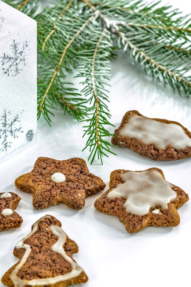 Новогоднее печенье с подарком и еловой веткой на белом фоне