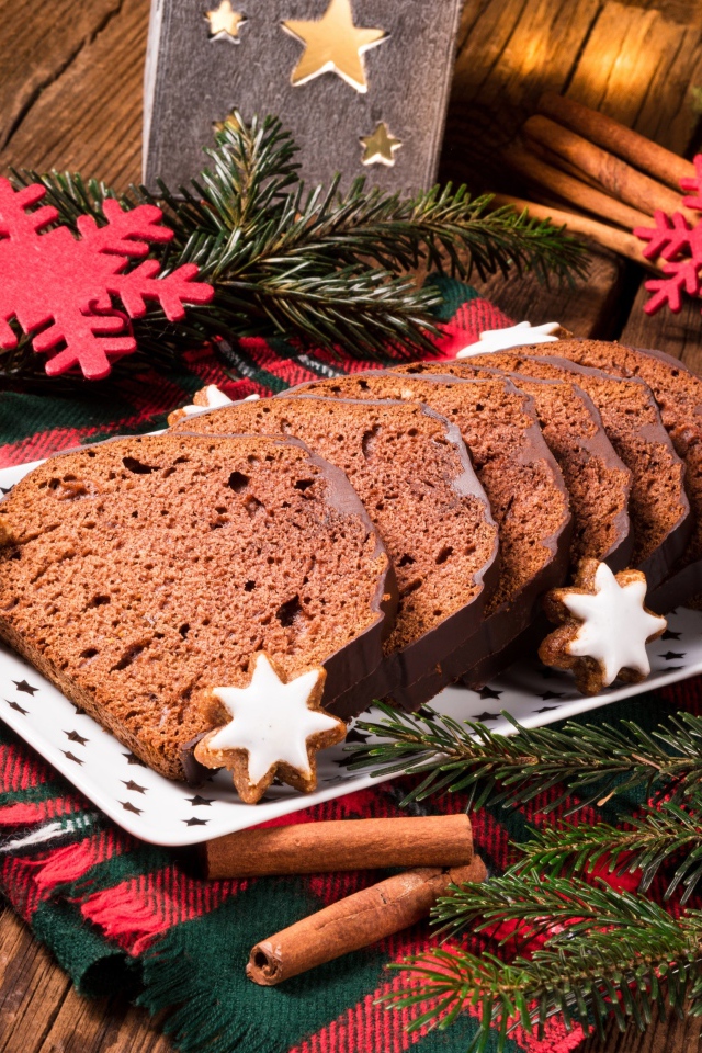 Рождественский кекс на столе с еловыми ветками и корицей