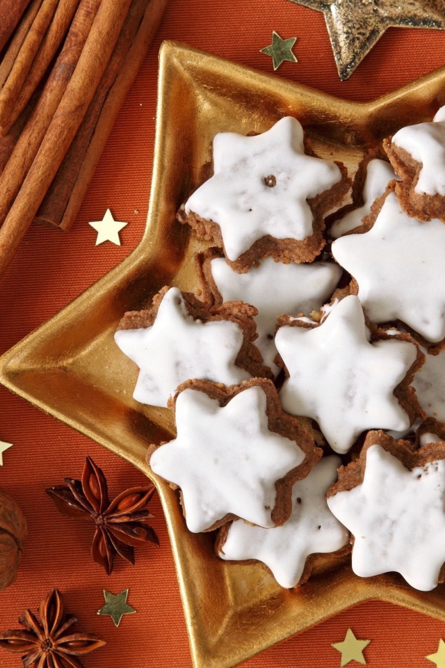 Печенье с глазурью на столе с орехами, корицей и бадьяном