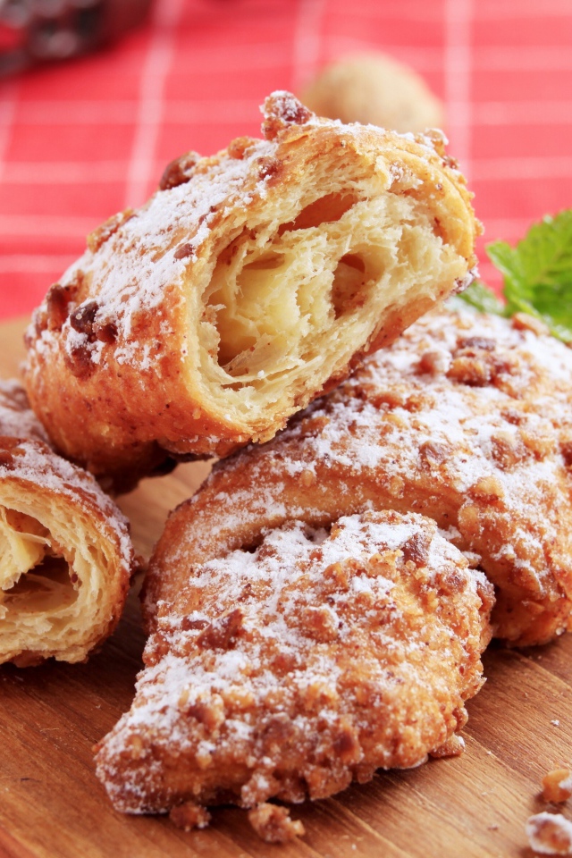 Круассаны с орехом и сахарной пудрой на разделочной доске