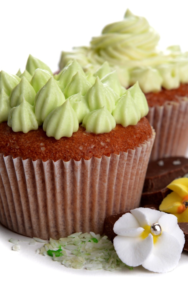 Кексы с кремом, шоколадом и корицей на белом фоне