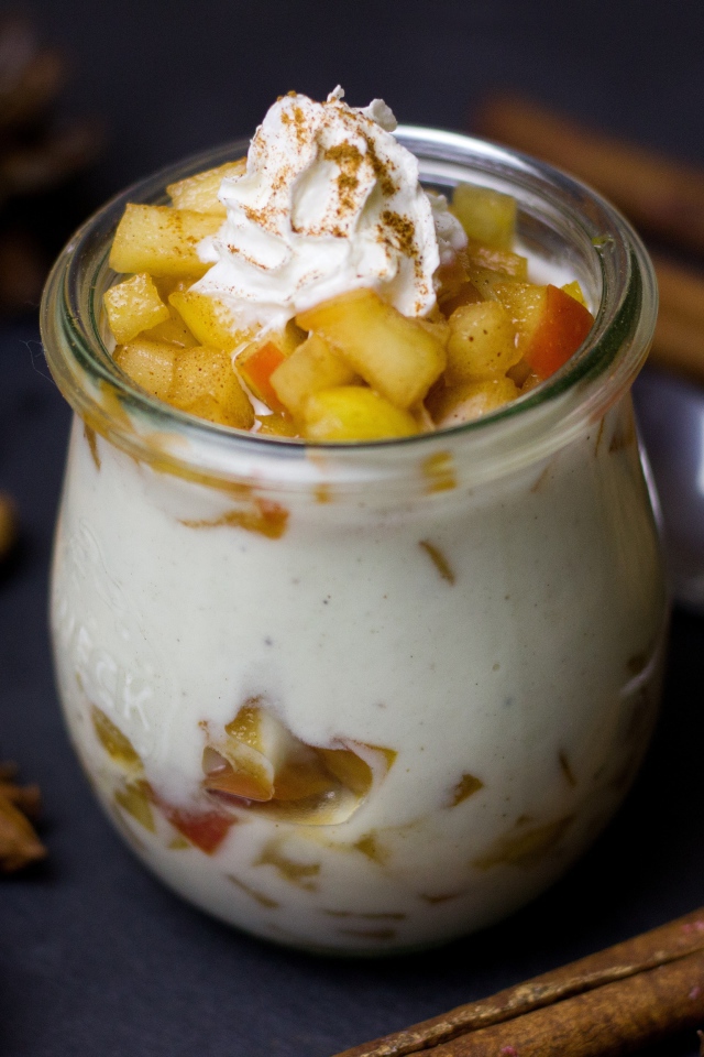 Десерт из йогурта с фруктами на столе с пряностями