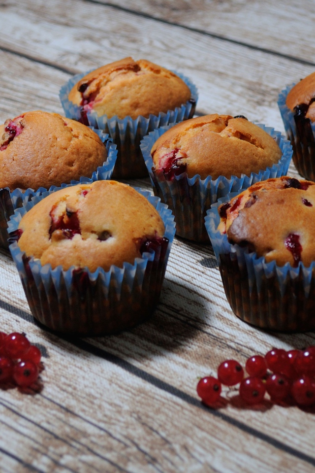 Свежие кексы с красной смородиной на деревянном столе 