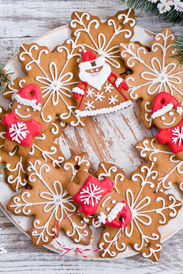 Имбирное новогоднее печенье с еловыми ветками на деревянном столе