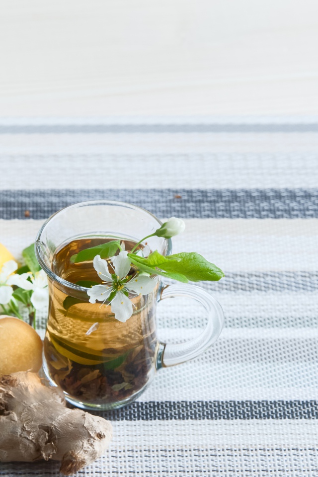 Стеклянные чашки с чаем на столе с имбирем и лаймом