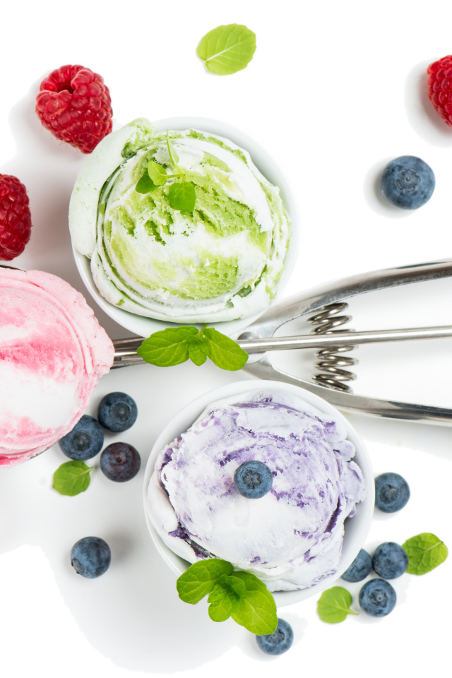 Шарики мороженого на столе с ягодами черники и малины 