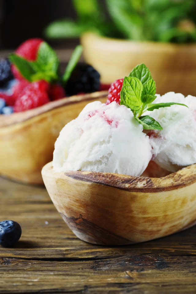 Шарики мороженого с ягодами в деревянной посуде