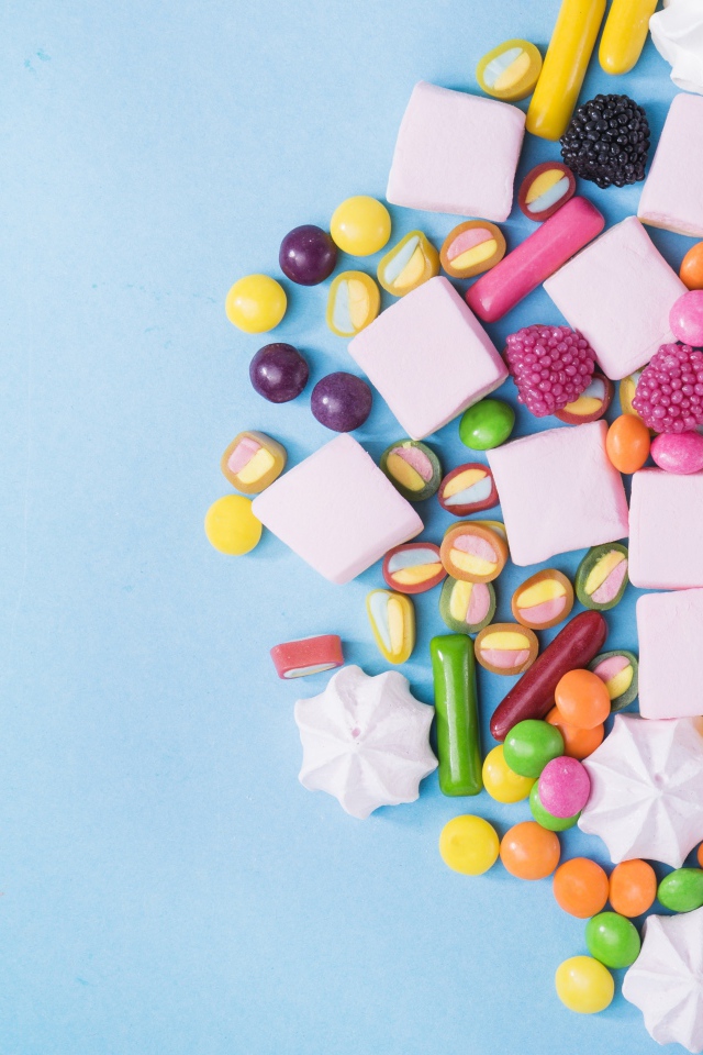 Маршмеллоу, конфеты и желе на голубом фоне