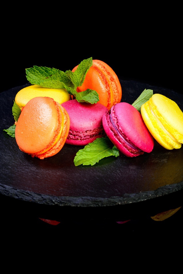 Разноцветный десерт макарон на черном фоне