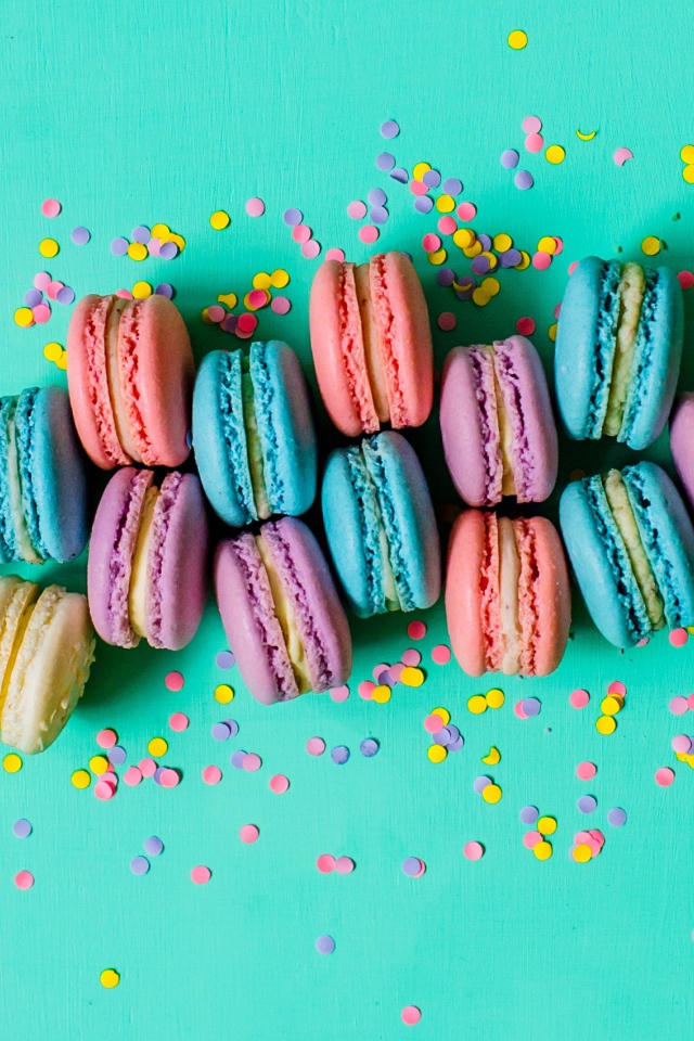 Разноцветный десерт макарун на голубом фоне с конфетти