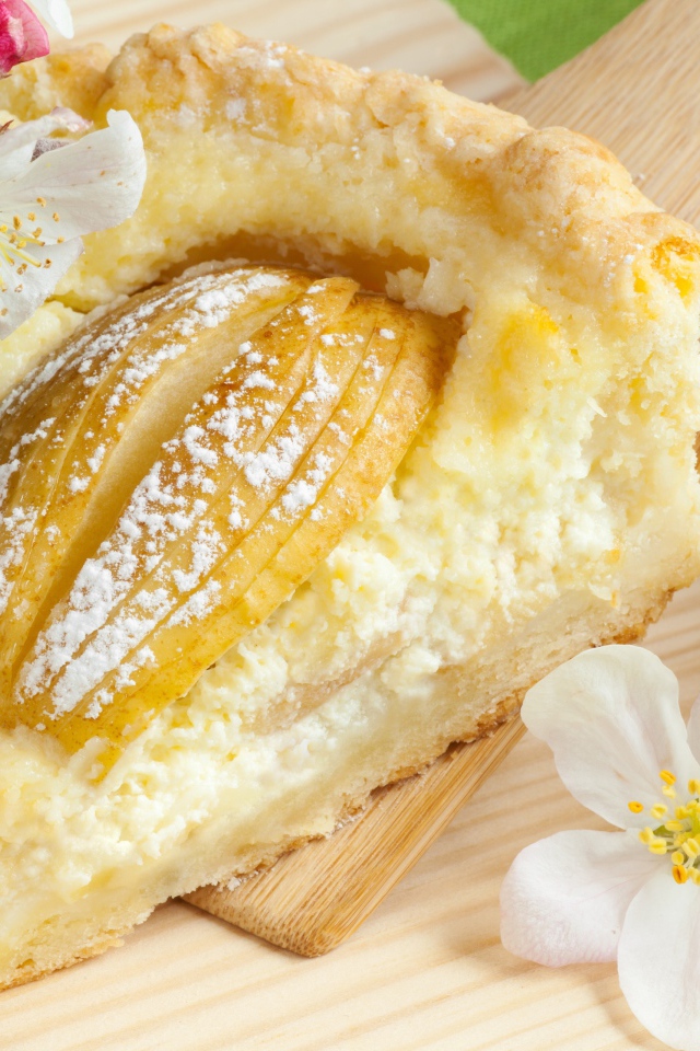 Кусок пирога с яблоками на деревянной лопатке с цветами яблони