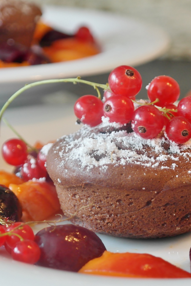 Кексы с красной смородиной на тарелке с ягодами 