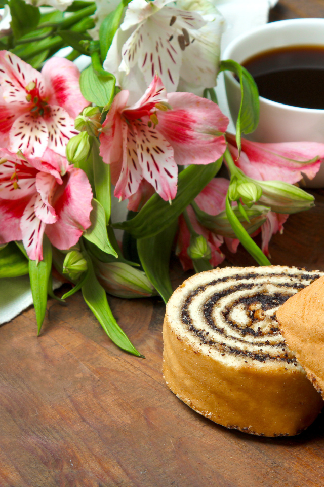 Рулет с маком на столе с цветами альстрёмерия и чашкой кофе